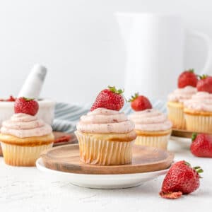Strawberry Filled Cupcakes topped with fresh strawberries scattered and ready to eat