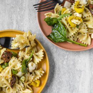 Two plates loaded with the Best Lemon Pesto Pasta Salad