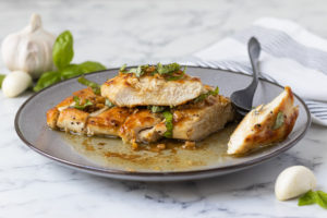 Juicy Chicken Slices topped with fresh basil and smothered in garlic sauce.