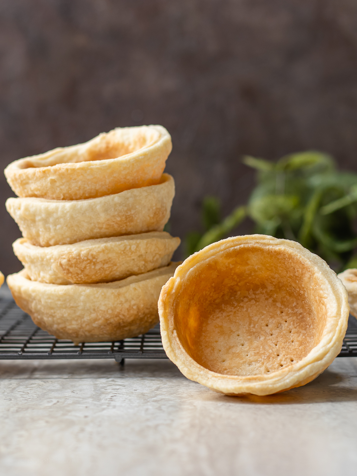 Stack of Mini Pie Crust Shells with one flipped to see the inside.