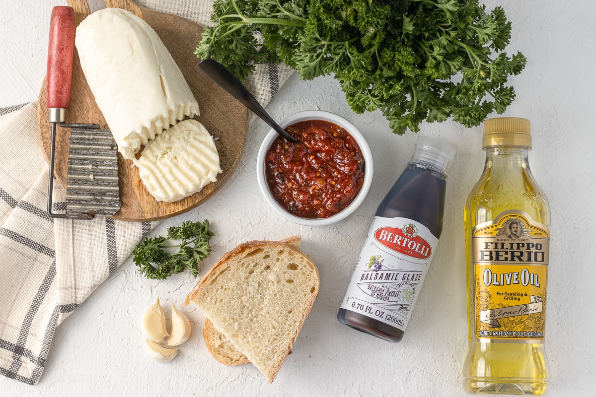 Ingredients for Tomato Chutney Bruschetta with Mozzarella; Mozzarella, Garlic, Bread, Balsamic Glaze, Olive Oil, Parsley, Tomato Chutney.