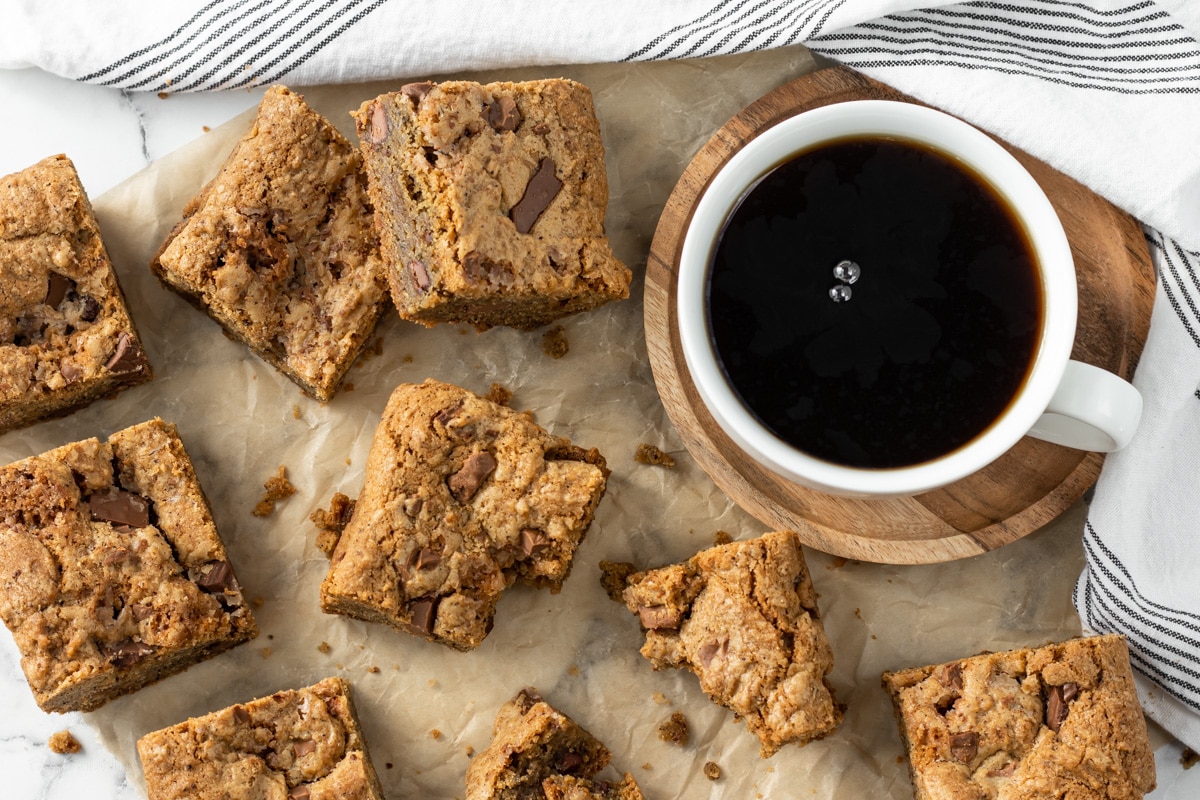Overhead shot of slices of cookie bars and a hot cup of coffee