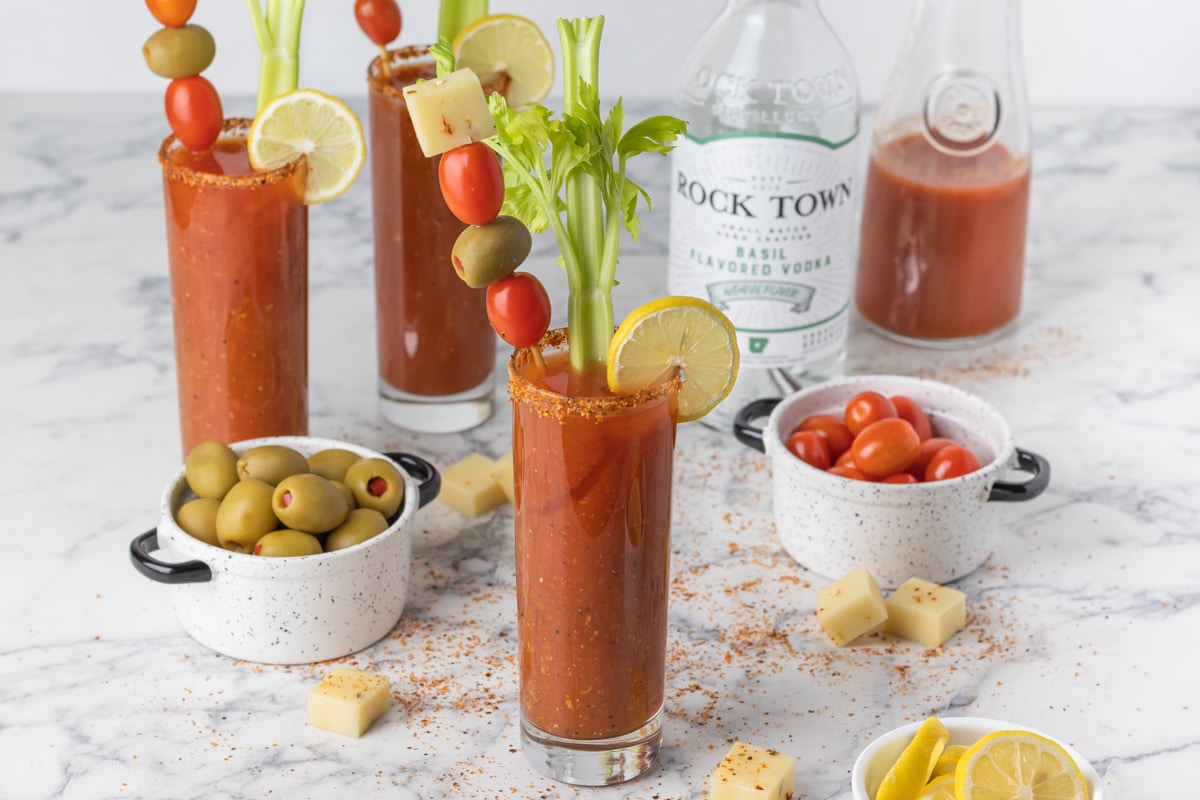 Basil Bloody Mary rurrounded by toppings and Tajin