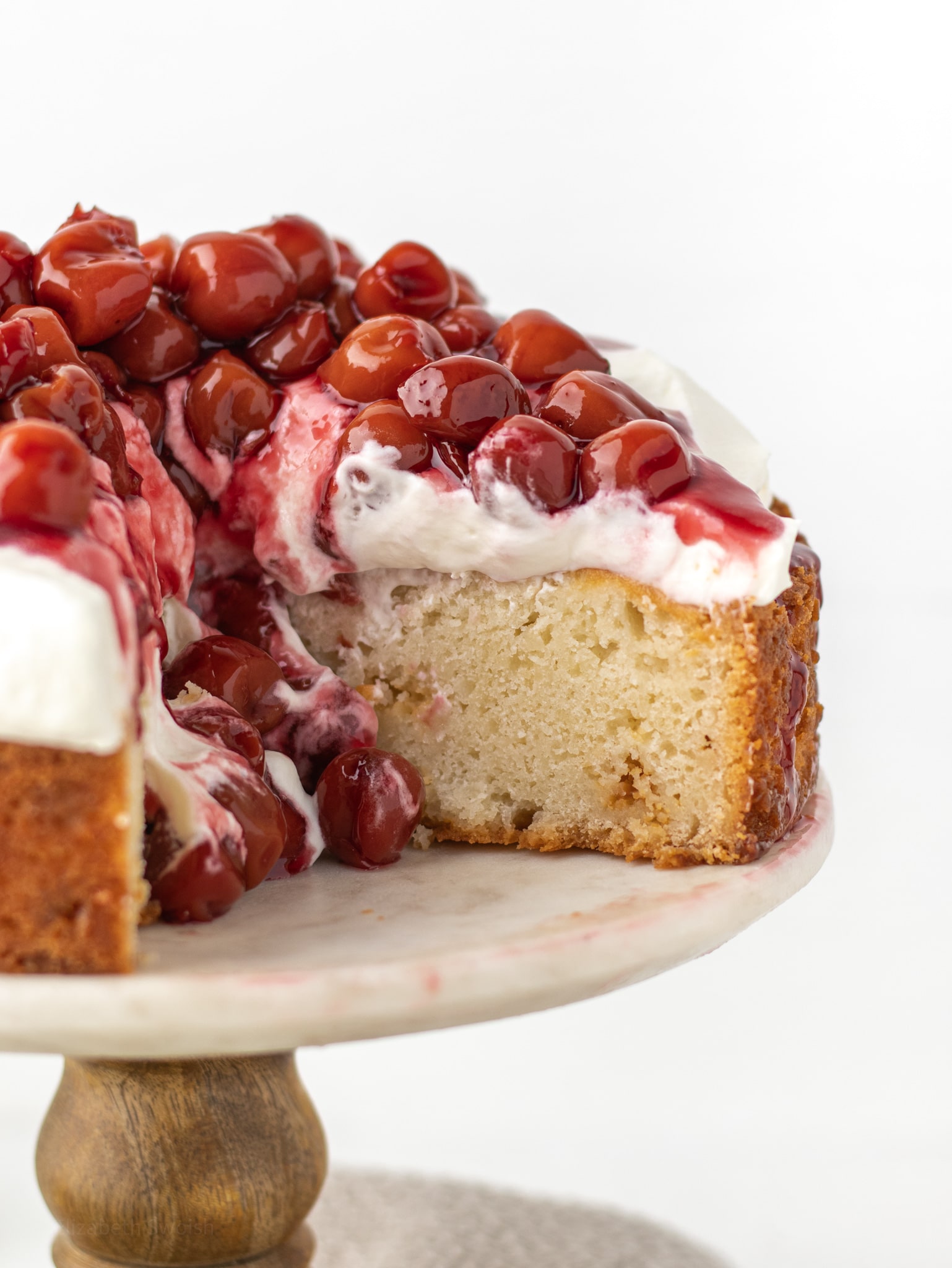 White Forest Cherry cake with a slice missing. 