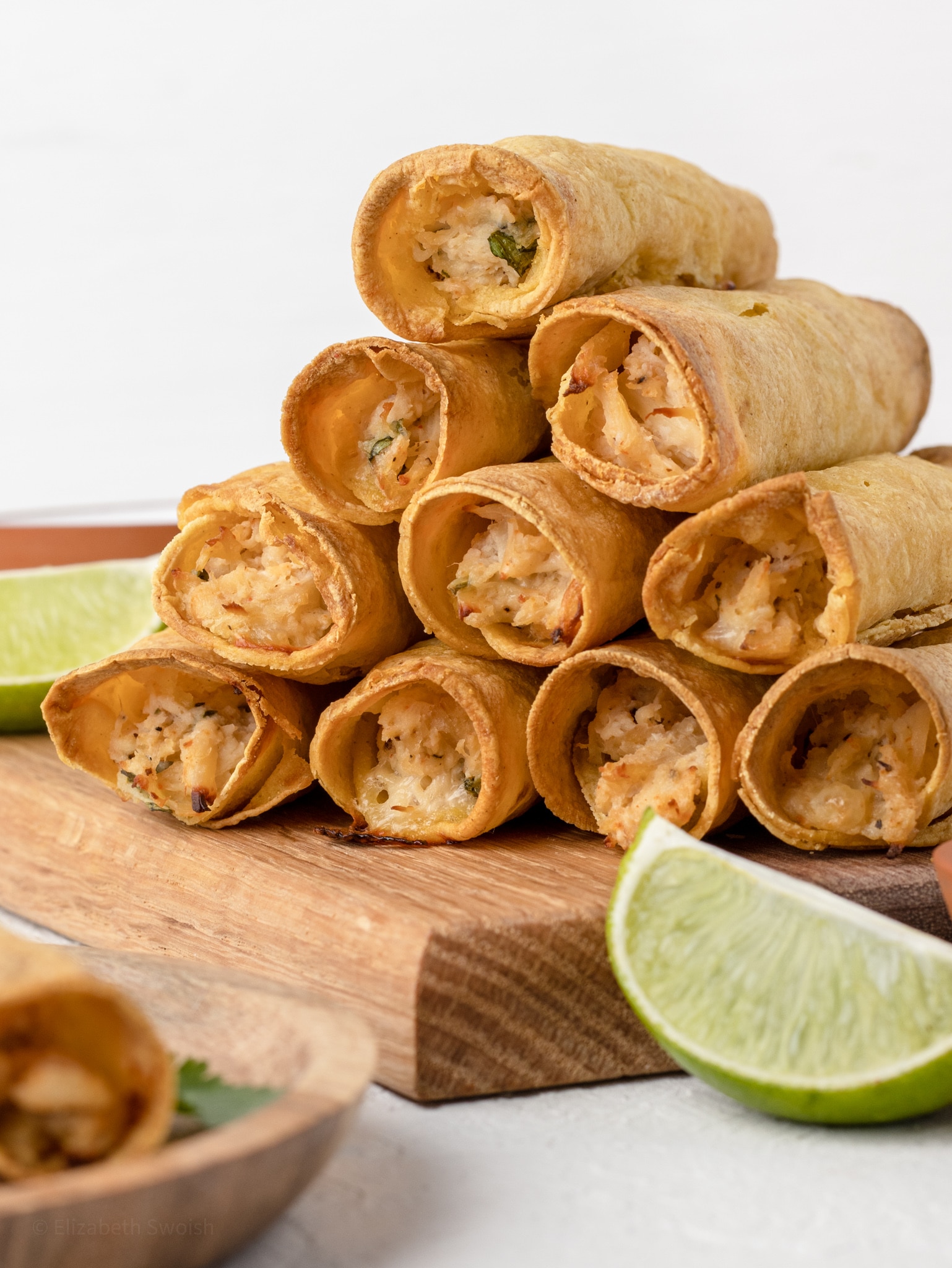 Tall stack of Chicken Lime Taquitos ready to be ate.
