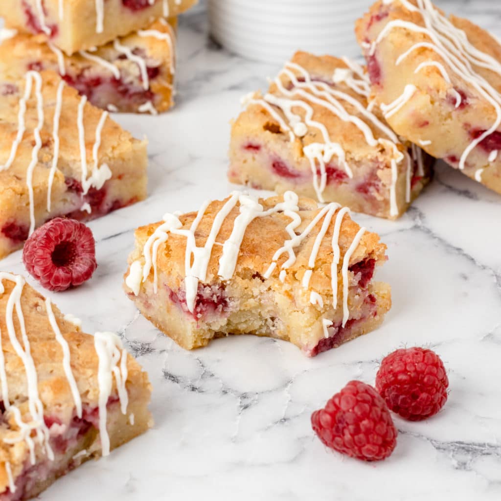 Bite out of a soft and chewy Raspberry White Chocolate Blondie.
