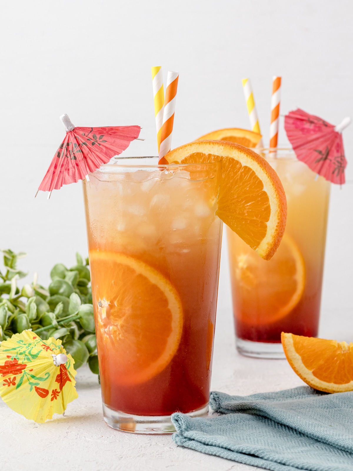 Sunrise Mocktail Spritzer decorated with orange slices, mini umbrellas, and straws. 