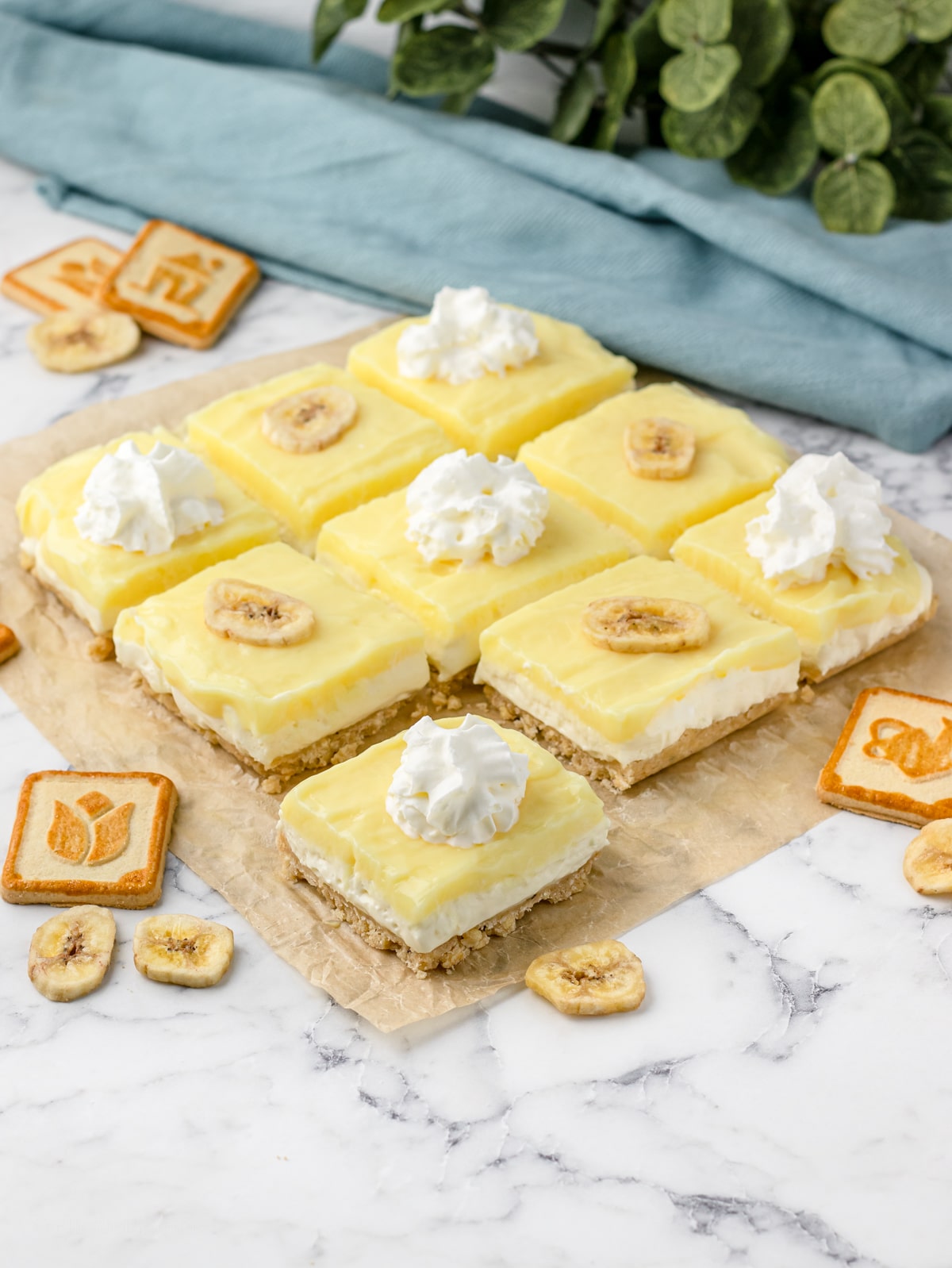 Banana Pudding Cheesecake Bars cut in 9 slices topped with whipped cream and banana chips.