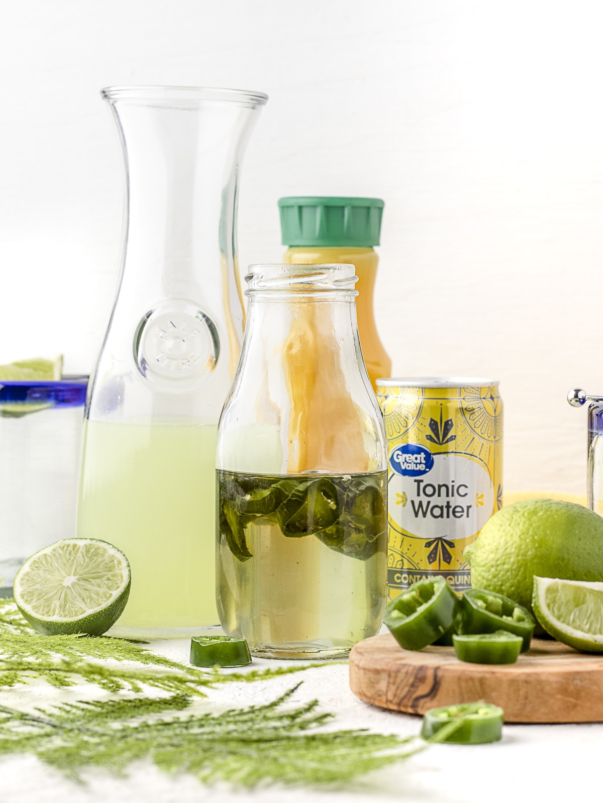 Ingredients needed, Jalapeno simple syrup, orange juice, limeade, tonic water, lime slices, and jalapeno slices.