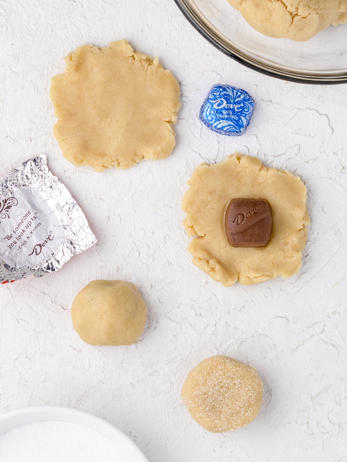 4 easy steps to stuff these cookies. Flatten a piece of dough, place chocolate in the center, form dough around chocolate, roll in granular sugar, and bake.