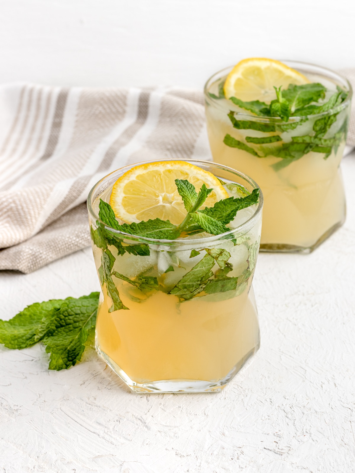 2 Lemon Mojito Mocktails with fresh mint and lemon slices.