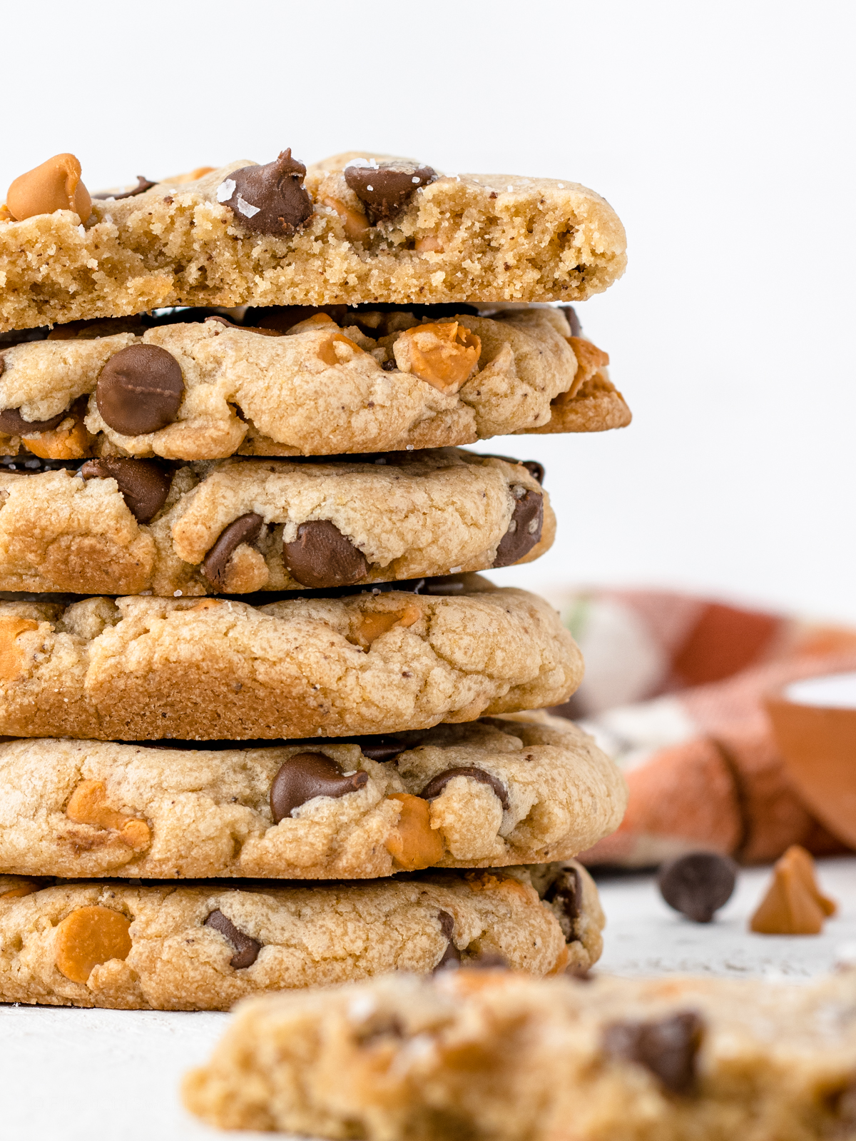Close up of stack of cookies to reveal browned butter bits, semi sweet chocolate chips, and butterscotch chips.