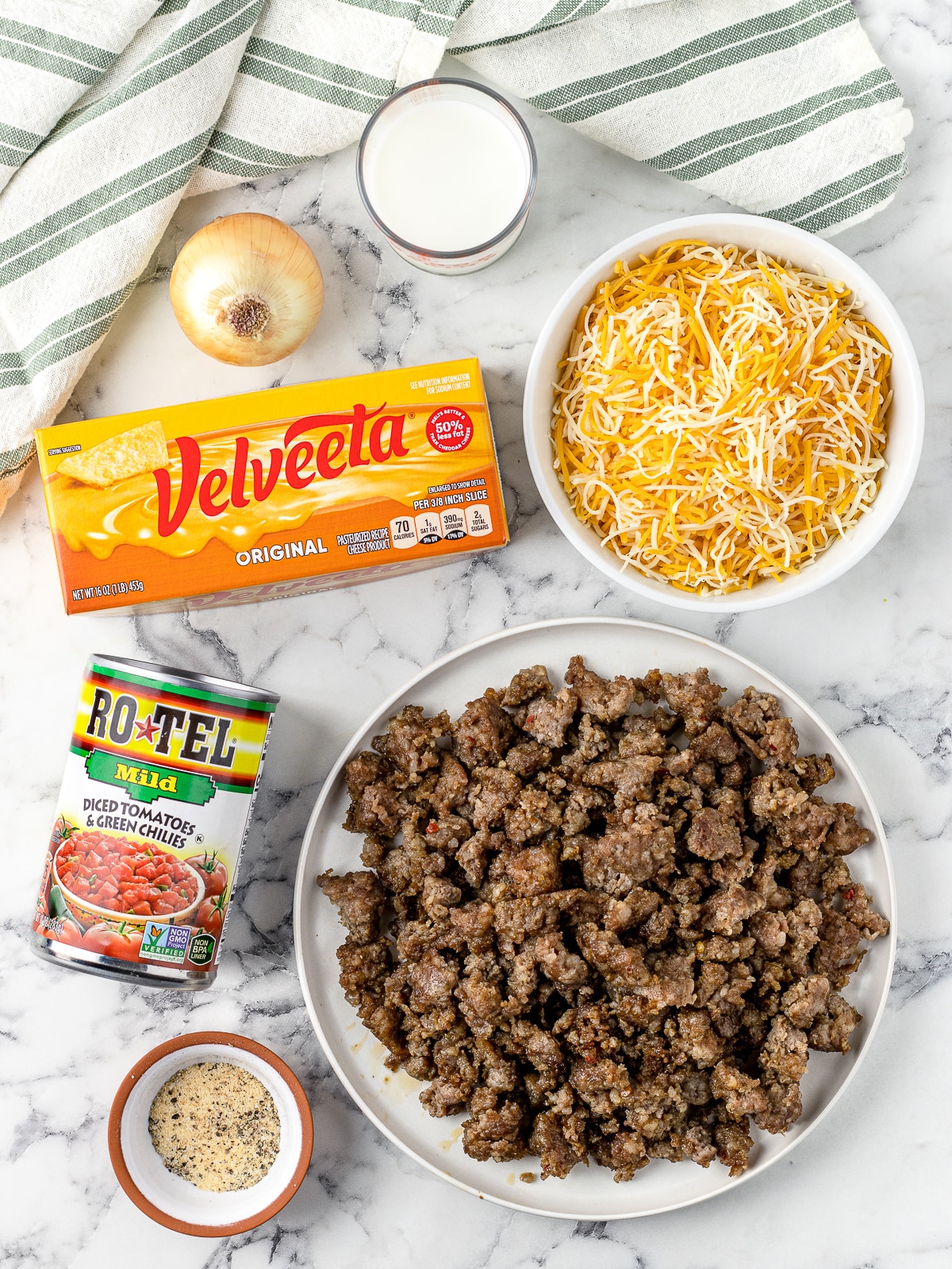 Ingredients. Velveeta cheese, breakfast sausage, rotel and chilies, mexican cheese, diced onion, evaporated milk, garlic powder, salt and pepper.