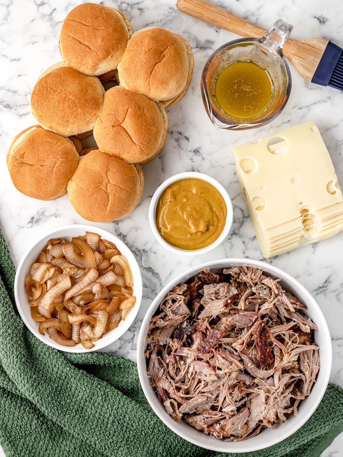 Ingredients. Slider buns, pulled pork, BBQ sauce, sauteed onions, swiss cheese, seasoned melted butter.
