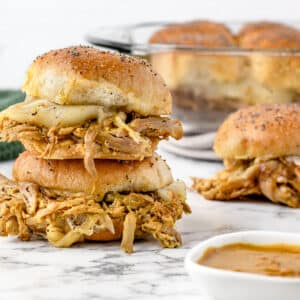 Stack of 2 Pulled Pork Sliders with sauce on the side.