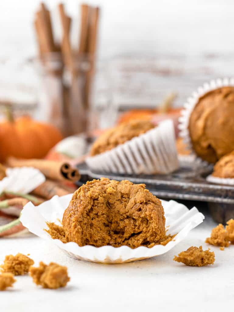 A bite taken out of a pumpkin muffin to see the airy consistency.