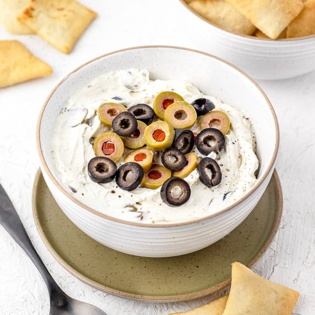 A bowl of Olive Dip ready to eat with pita chips