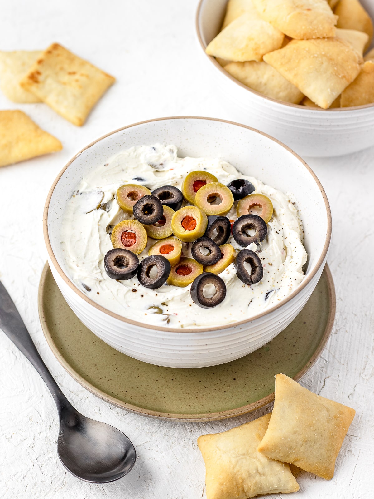 Big bowl of olive dip and pita chips on the side.