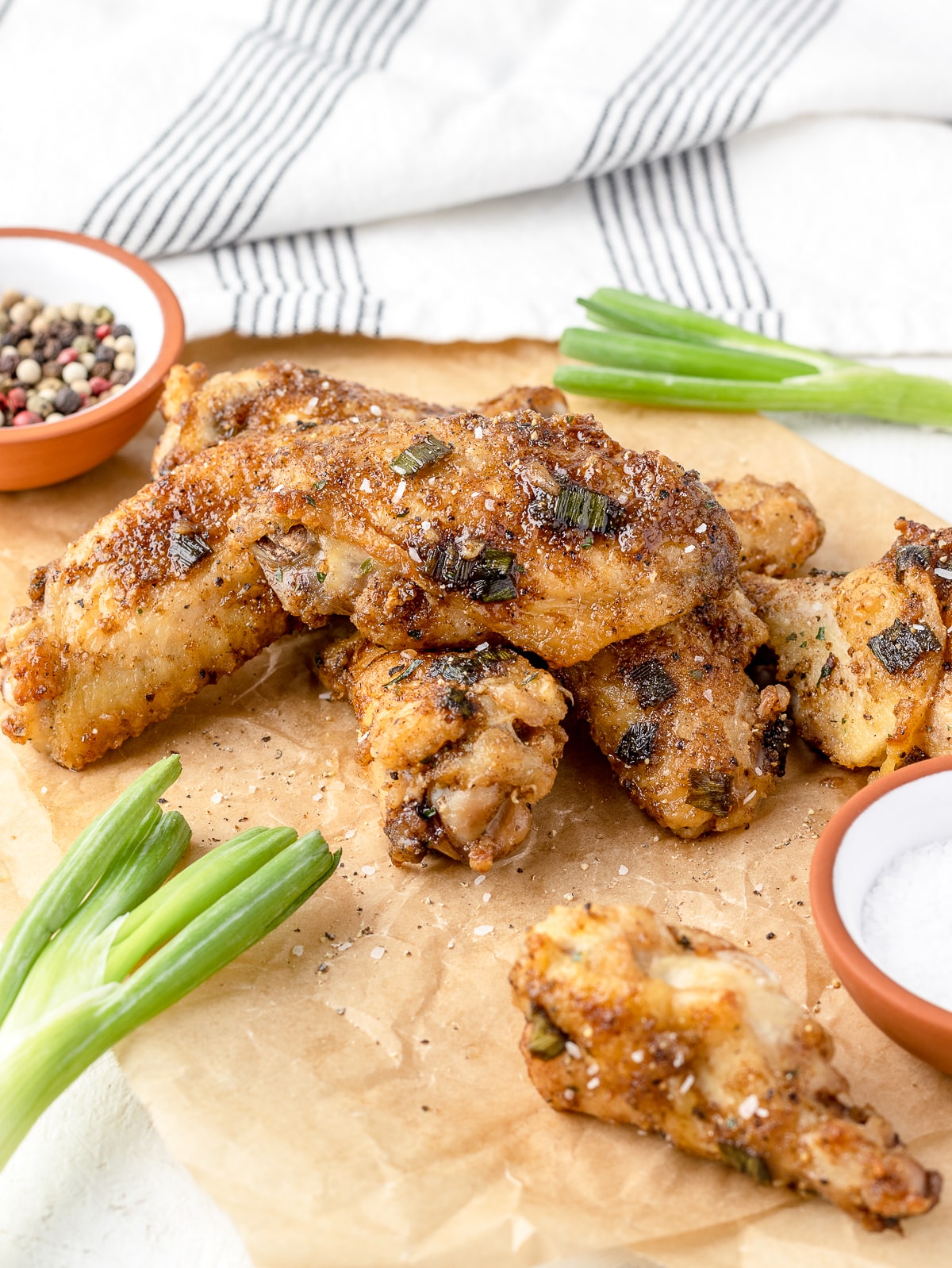 Salt and Pepper Chicken Wings on parchment paper ready to grab and eat.
