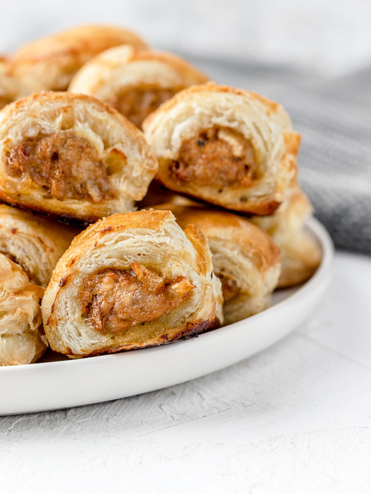 flaky, golden brown Chicken Sausage Rolls stacked and ready to eat.
