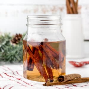 Cinnamon Simple Syrup in a glass mason jar with cinnamon sticks in the syrup.