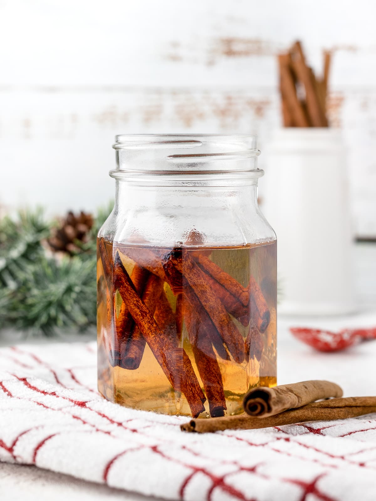 Cinnamon Syrup in a glass mason jar with cinnamon sticks in the syrup.