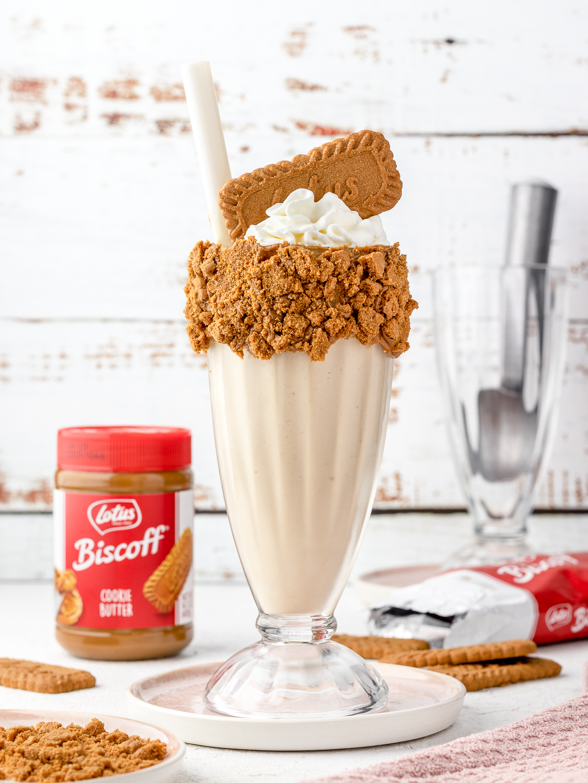 Biscoff Milkshake with a cookie crumb rim with whipped cream and a Biscoff cookie on top.