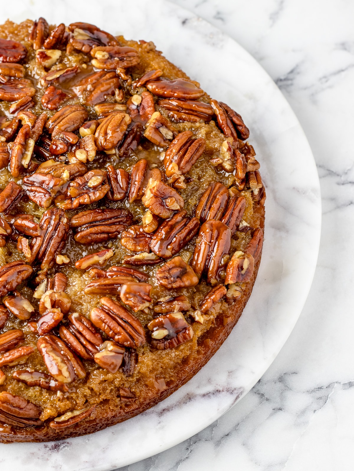 A whole Pecan Upside Down Cake, zoomed in on the pecans, and gooey caramel top.