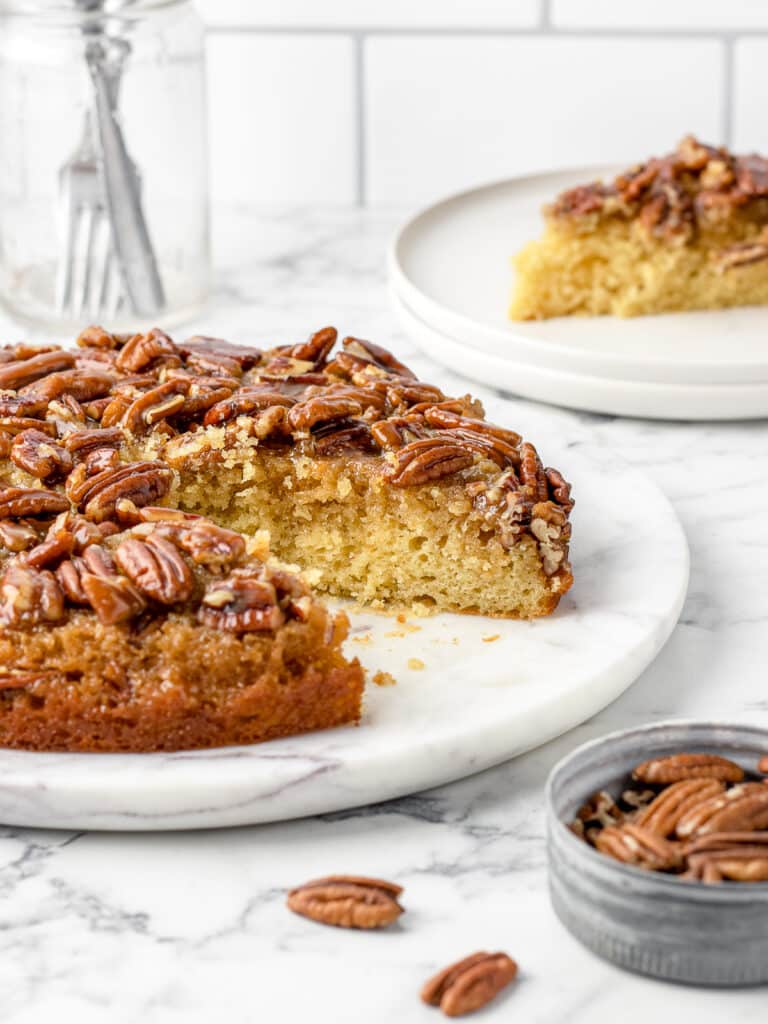 Cut out of the cake with a slice on the side, extra pecans, and forks.