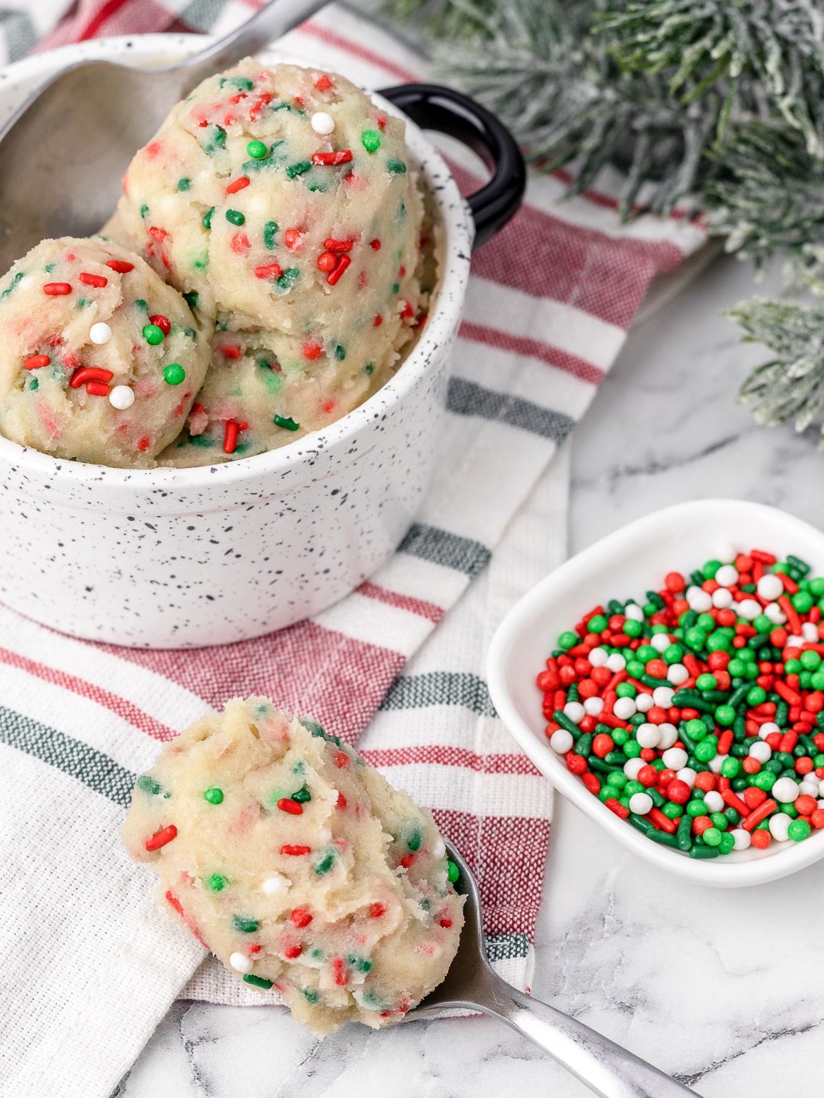 Edible Cookie Dough with two spoons scooping it and sprinkles on the side.