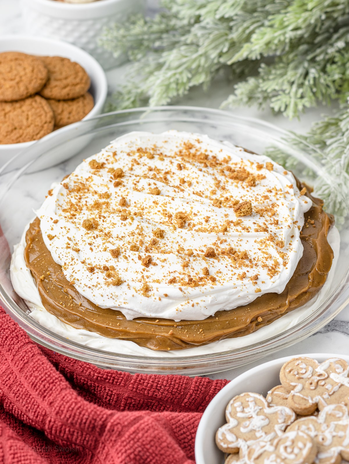 Layer 3. Whipped cream and crushed gingersnaps on top of molasses pie pudding and no bake cheesecake in a pie plate.
