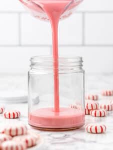 Pouring peppermint simple syrup into a jar.