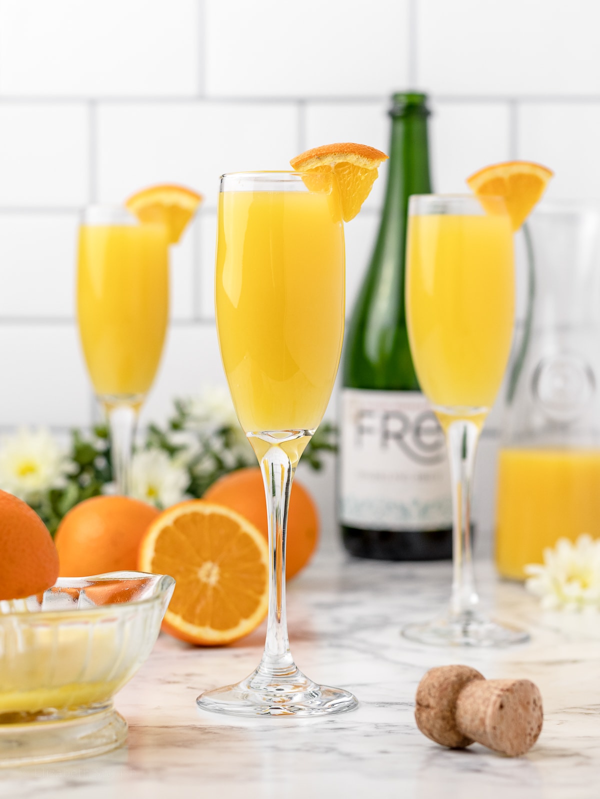 3 mimosas ready to drink with friends. More orange juice and non alcoholic champagne on the side.