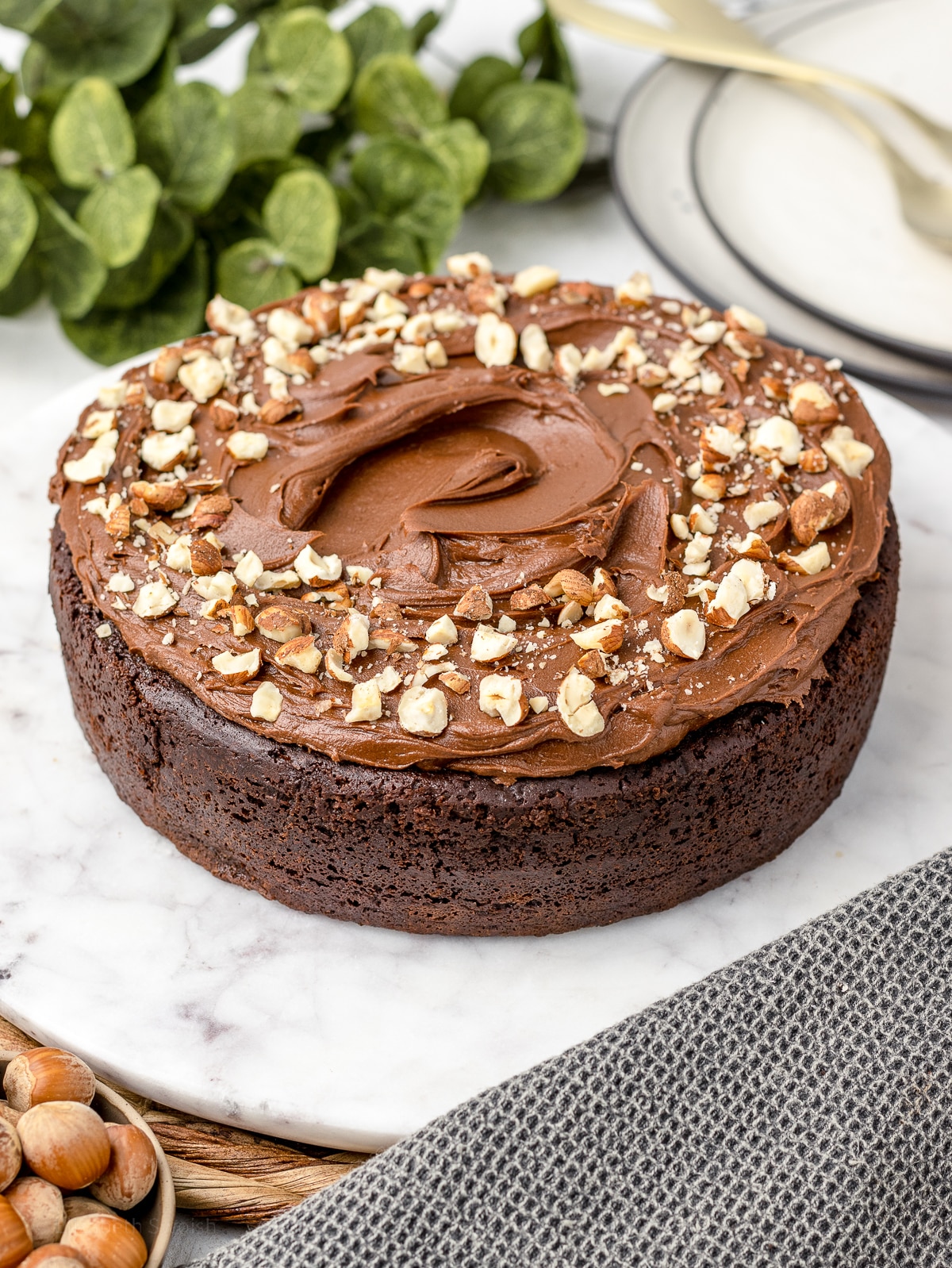 Decorated Chocolate Nutella Cake with Nutella Buttercream and chopped hazelnuts on top.