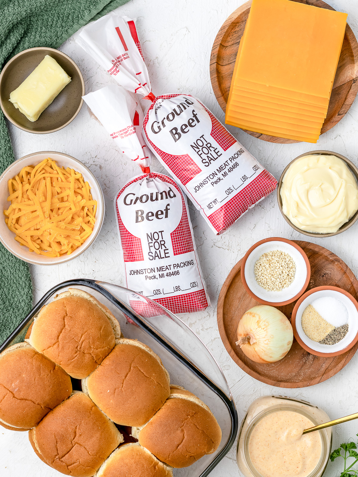 Ingredients needed to make cheesy ground beef sliders with a sriracha aioli.