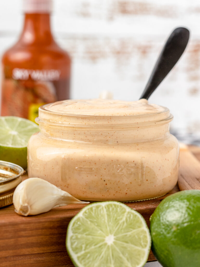 Creamy sriracha mayo sauce with a spoon ready to eat.