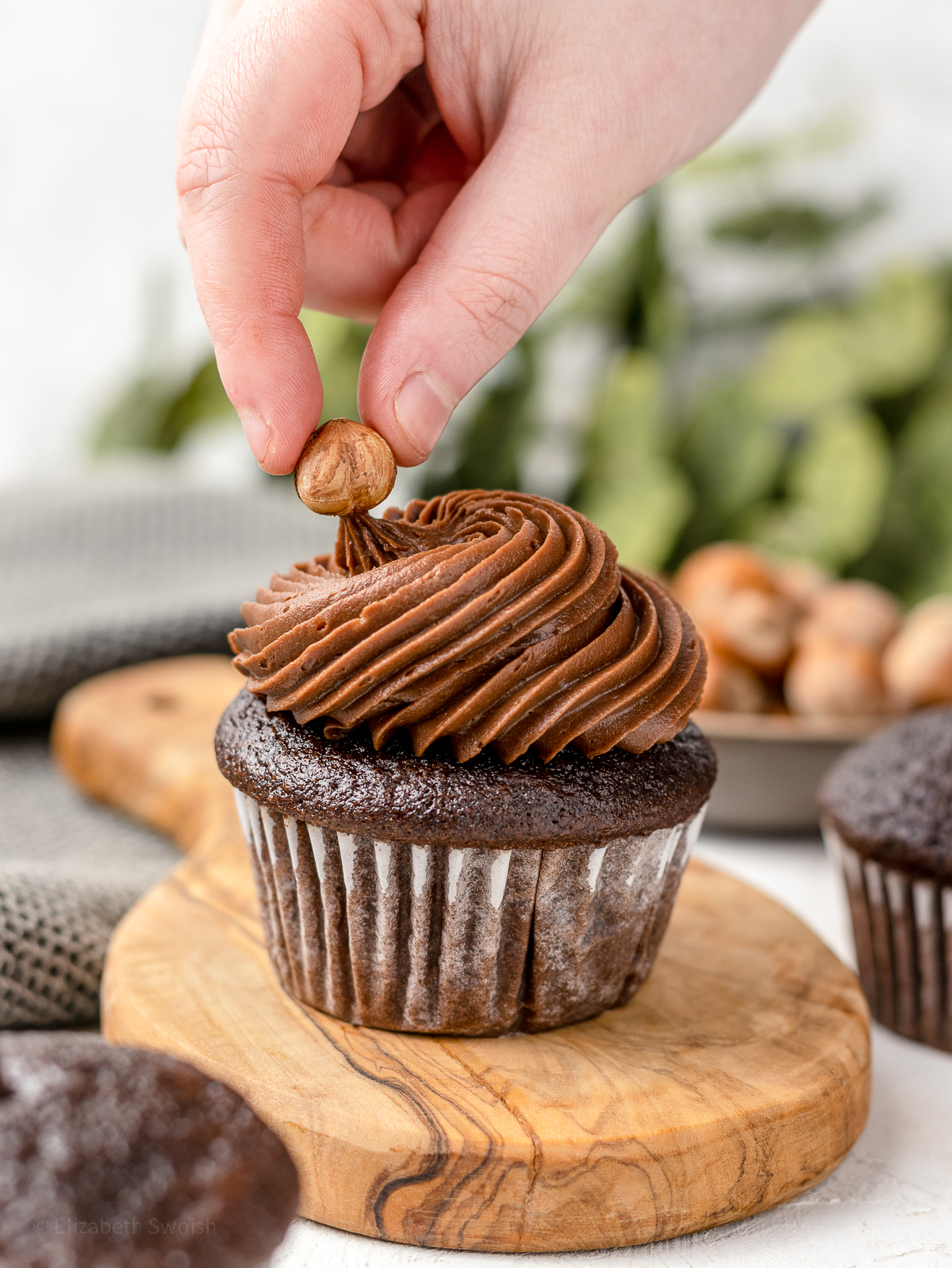 Topping cupcake with a roasted hazelnut.