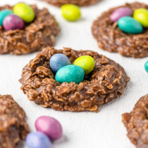 No bake birds nest cookies with candy eggs in them and more candy eggs around them.