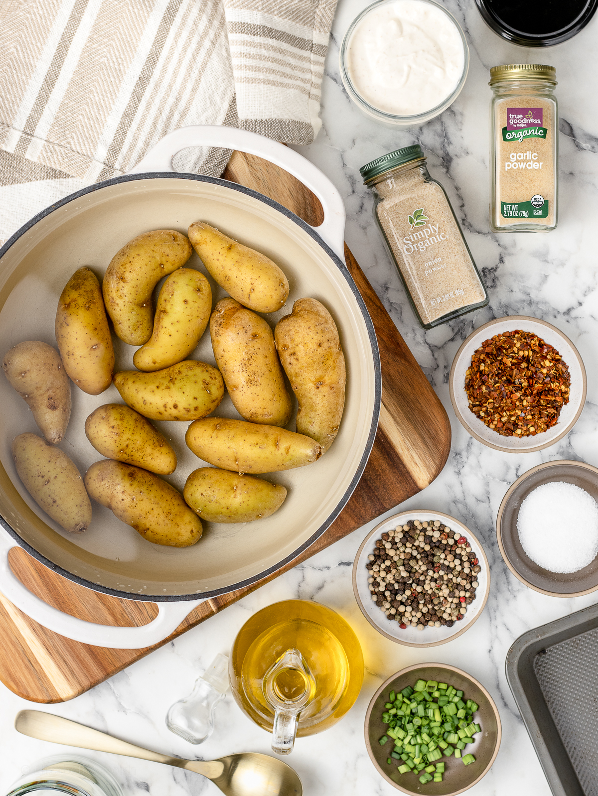 Ingredients. Fingerling potatoes in a salted water pot with olive oil, salt, pepper, garlic powder, onion powder, red pepper flakes, and creamy dipping sauce.