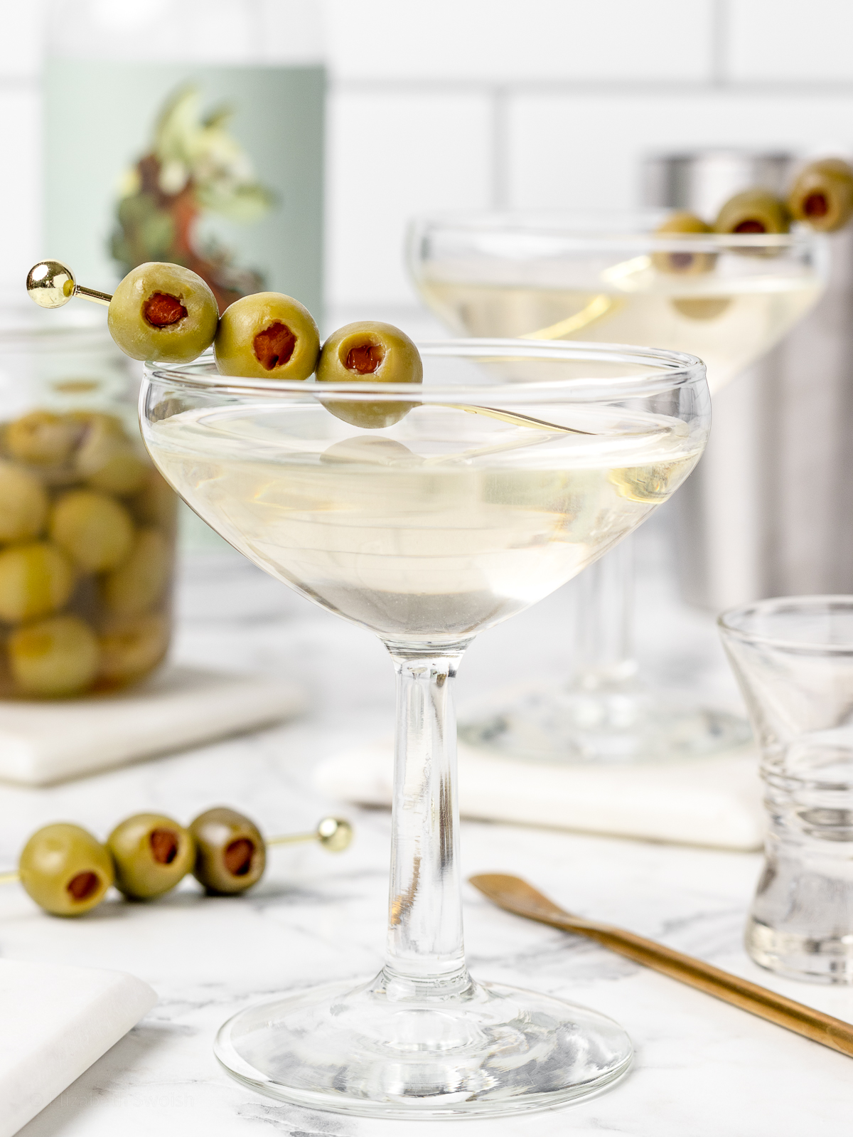 Close up of 3 olives on a cocktail pin garnishing the mocktail.