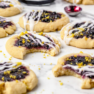 Lemon Blueberry Cookies topped with lemon glaze and lemon zest with extra blueberry jam on the side.