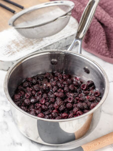 Fresh blackberries and water in a saucepan cooking down.