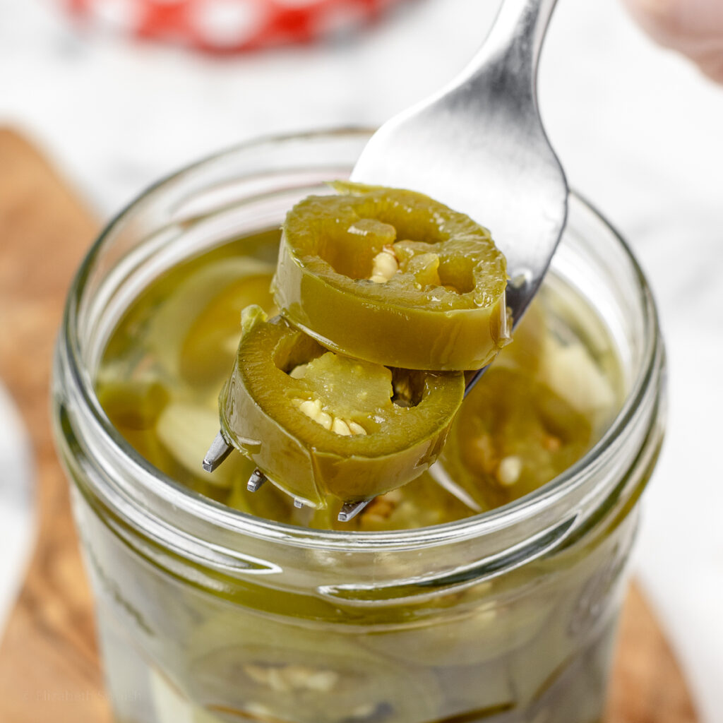 Fork filled with homemade quick pickled jalapenos.