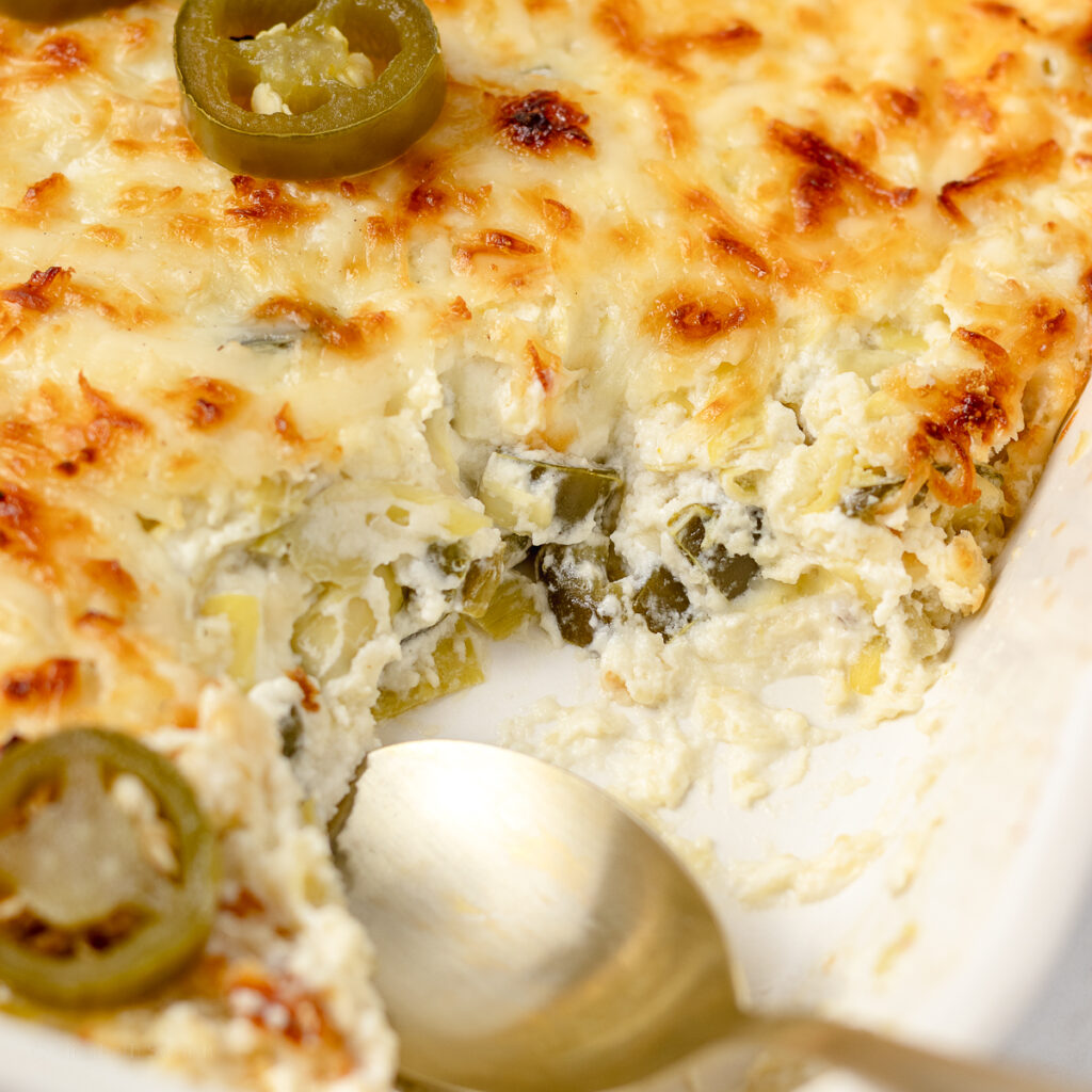 Jalapeno Artichoke Dip. Close up view to see the creamy dip with chunks of pickled jalapeno and artichoke hearts.