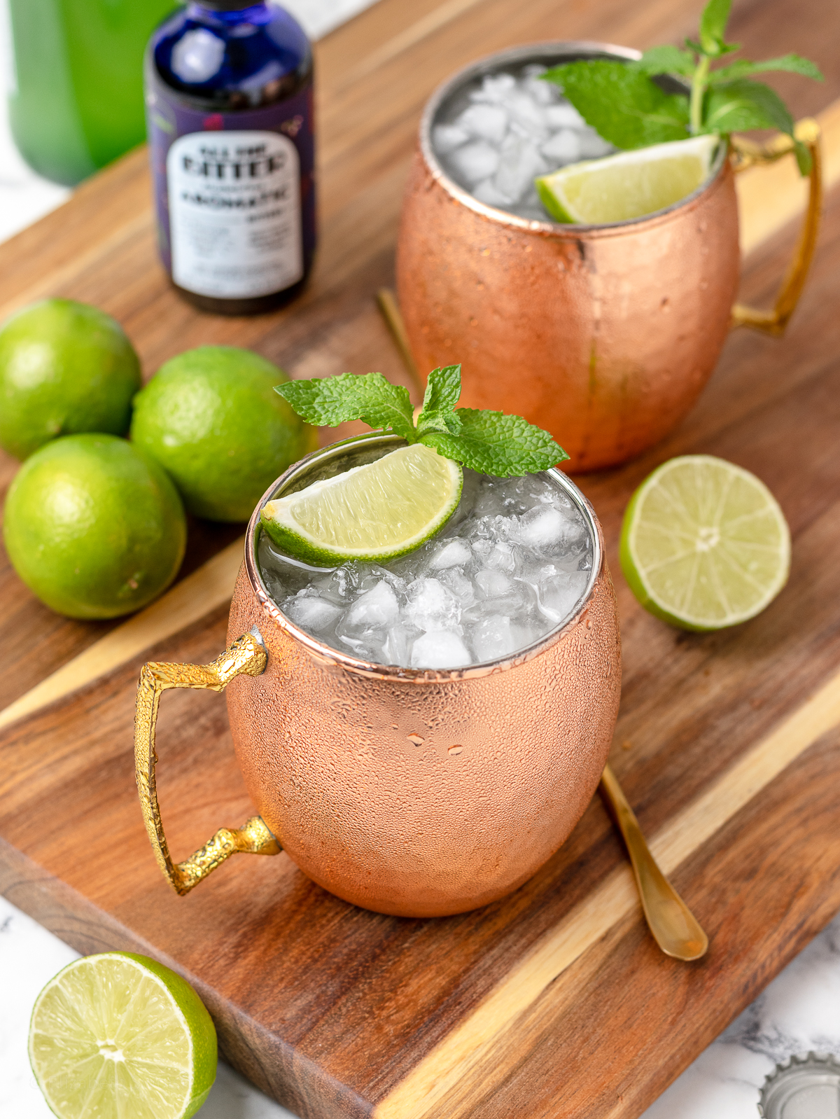 2 super cold non alcoholic Moscow Mules ready to drink with more aromatic bitters on the side.