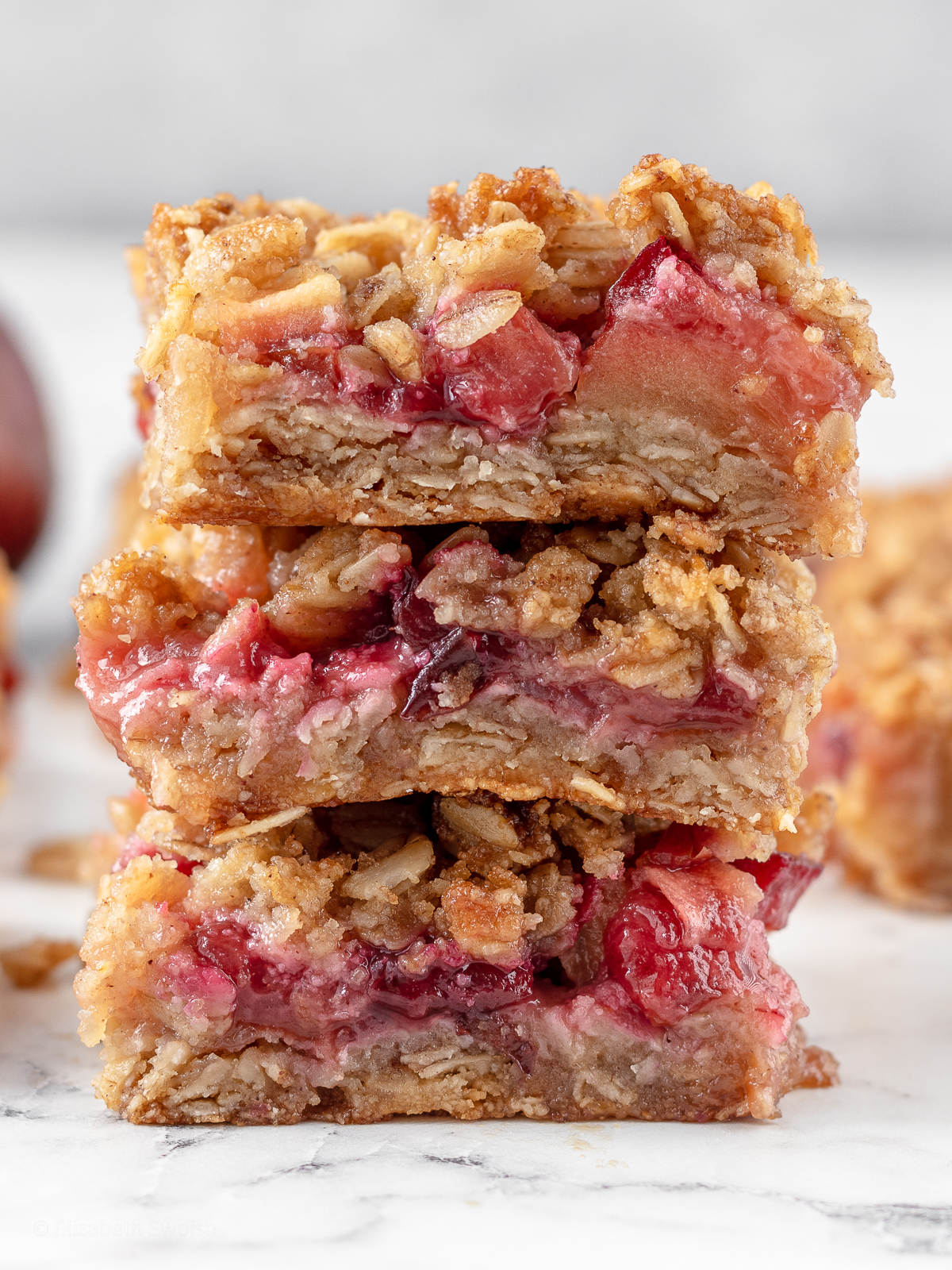 Tall stack of apple and plum crumble bars.