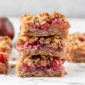 Tall stack of crispy, gooey, fruity apple and plum crumble bars.