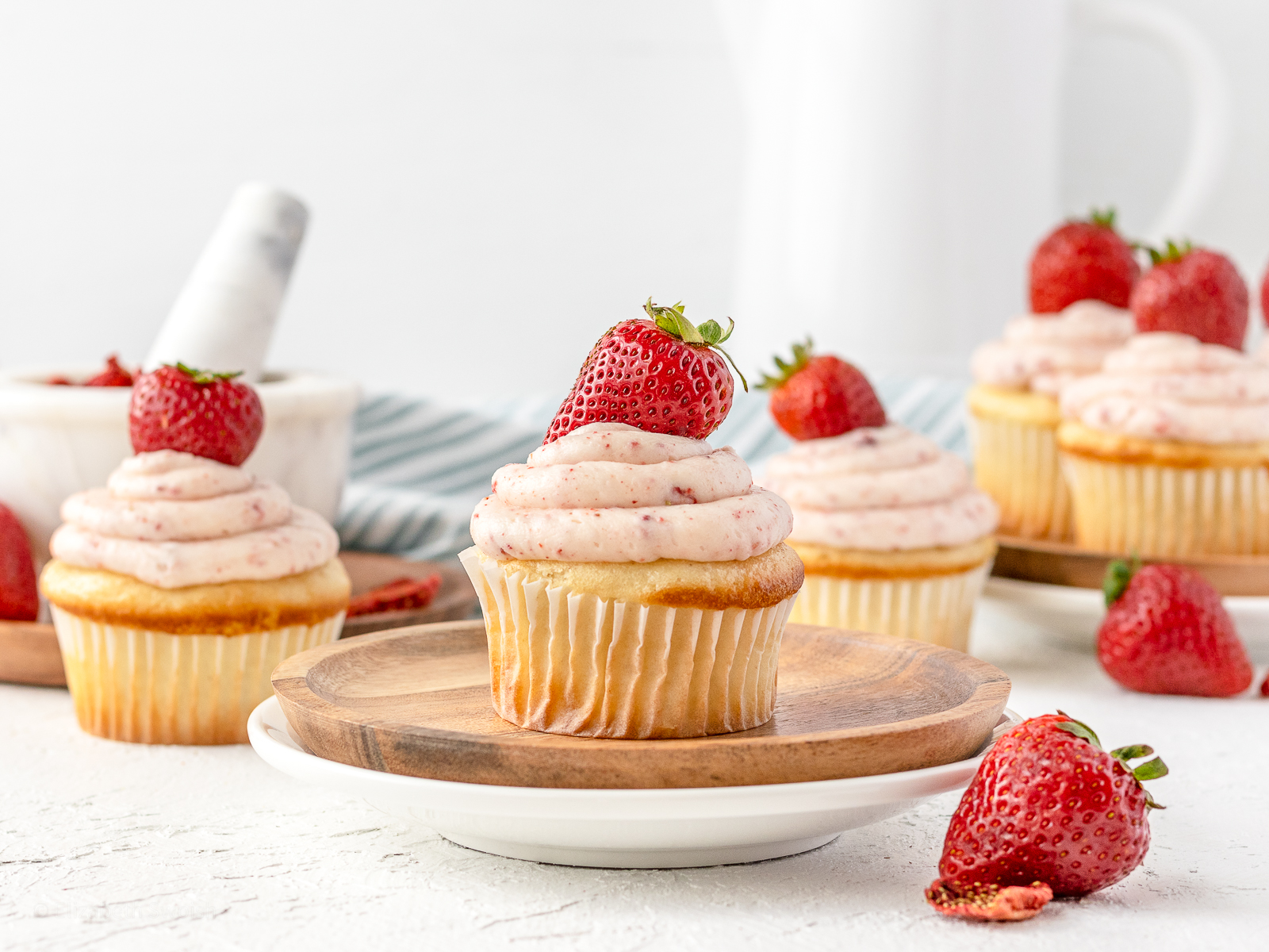 Strawberry Jam Filled Cupcakes topped with fresh strawberries scattered and ready to eat