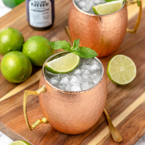 2 super cold non alcoholic Moscow Mules ready to drink with more aromatic bitters on the side.