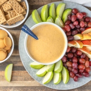 A tray of apples, grapes, vanilla wafers and graham crackers with Maple Pumpkin Fruit Dip.